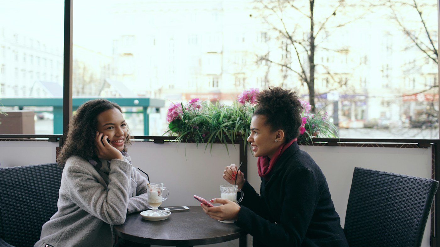 Two women sharing a moment at a street café